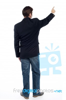 Back Pose Casual Guy Pointing At The Copy Space Area Stock Photo