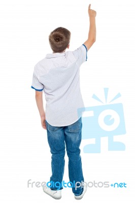 Back View Of Boy Shows Pointing Up Stock Photo