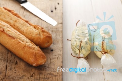 Baguette With Herb Butter And Rosemary Thyme On Rustic Wooden Background Stock Photo