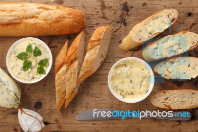 Baguette With Herb Butter And Rosemary Thyme On Rustic Wooden Background Stock Photo