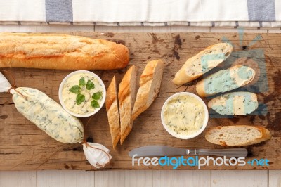 Baguette With Herb Butter And Rosemary Thyme On Rustic Wooden Background Stock Photo