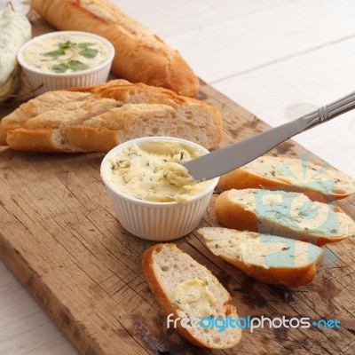 Baguette With Herb Butter And Rosemary Thyme On Rustic Wooden Background Stock Photo