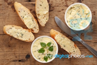 Baguette With Herb Butter And Rosemary Thyme On Rustic Wooden Background Stock Photo