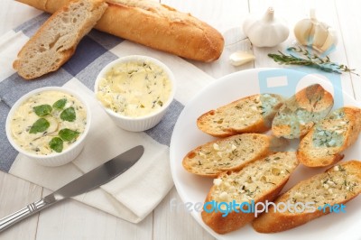 Baguette With Herb Butter And Rosemary Thyme On Rustic Wooden Background Stock Photo