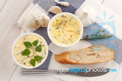Baguette With Herb Butter And Rosemary Thyme On Rustic Wooden Background Stock Photo