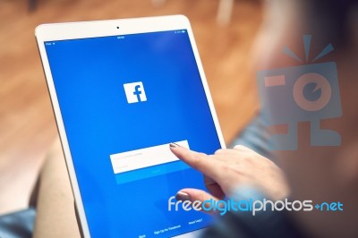 Bangkok, Thailand - January 16, 2018 : Hand Is Pressing The Facebook Screen On Apple Ipad Pro,social Media Are Using For Information Sharing And Networking Stock Photo