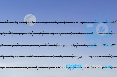 Barbed Wire Over Abstract Full Moon Sky Stock Photo