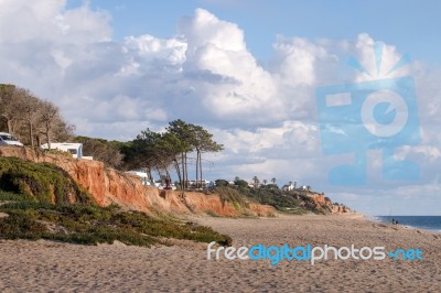 Beach And Cliffs In Quarteira Stock Photo