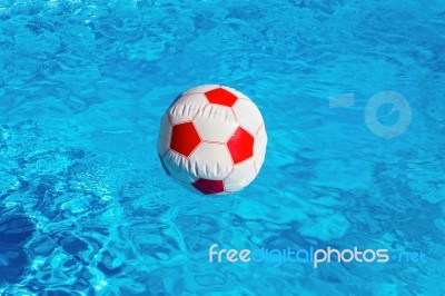 Beach Ball Floating  In Blue Swimming Pool Stock Photo