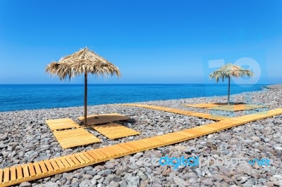 Beach Umbrellas With Path And Stones At Portuguese Sea Stock Photo