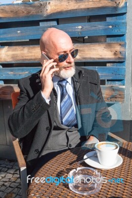 Bearded Businessman With Sunglasses Talking On Smartphone Stock Photo