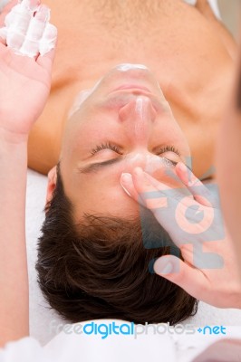 Beautician Applying Moisturizer Man's Face Stock Photo