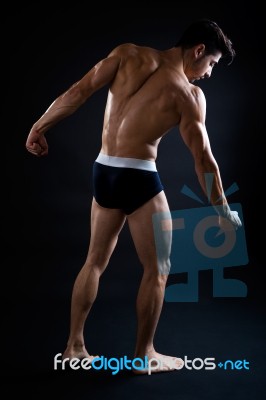 Beautiful And Muscular Man In Dark Background Stock Photo