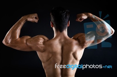 Beautiful And Muscular Man In Dark Background Stock Photo