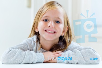 Beautiful Blonde Child Sitting At A Table In Kitchen Stock Photo