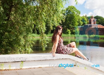 Beautiful Brunette Sitting Near The Lake Stock Photo