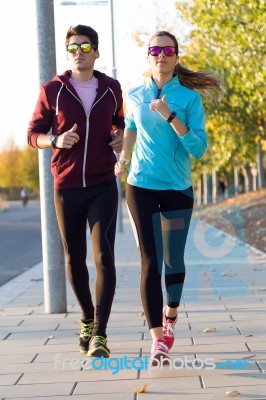 Beautiful Couple Running In The Street Stock Photo