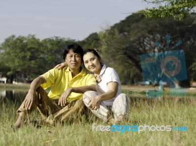 Beautiful Couple Sitting In Park Stock Photo