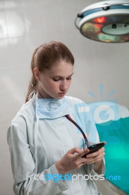 Beautiful Doctor Using A Smart Phone Stock Photo