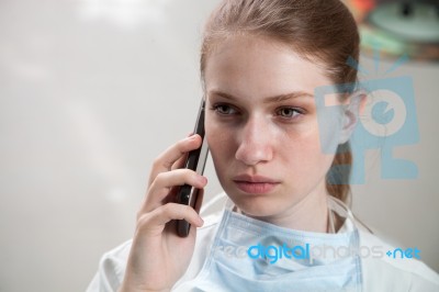 Beautiful Doctor Using A Smart Phone Stock Photo