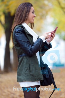 Beautiful Girl Chatting With Mobile Phone In Autumn Stock Photo