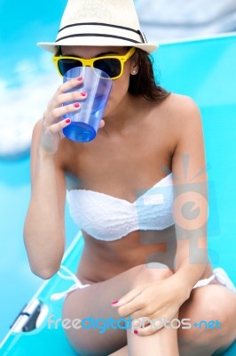 Beautiful Girl Drinking Water At The Swimming Pool Stock Photo