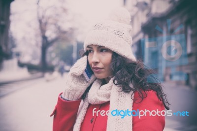 Beautiful Girl In Red Coat And Wool Cap And Gloves With Smartpho… Stock Photo