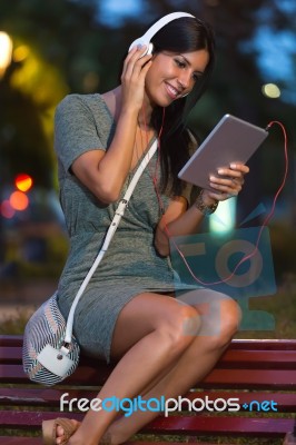 Beautiful Girl Listening To Music In The City At Night Stock Photo