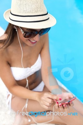 Beautiful Girl Listening To Music In The Swimming Pool Stock Photo