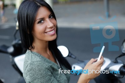 Beautiful Girl Posing At Camera In The City With Mobile Phone Stock Photo