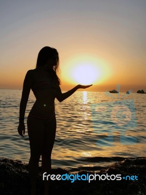 Beautiful Girl Silhouette Standing In The Sand During A Sunset On Golden Bay, Malta Stock Photo