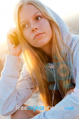 Beautiful Girl Sitting On The Roof And Listening To Music Stock Photo