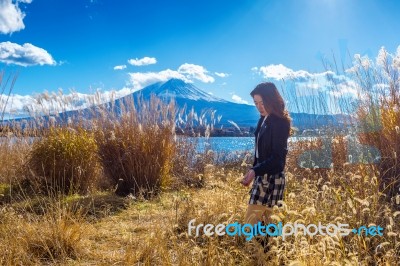 Beautiful Girl Standing At Kawaguchiko Lake With View Of Fuji Mountain, Autumn In Japan Stock Photo