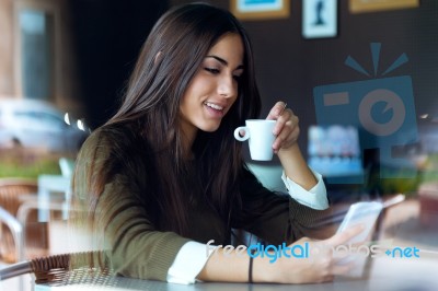 Beautiful Girl Using Her Mobile Phone In Cafe Stock Photo