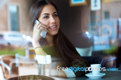 Beautiful Girl Using Her Mobile Phone In Cafe Stock Photo