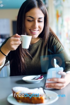 Beautiful Girl Using Her Mobile Phone In Cafe Stock Photo