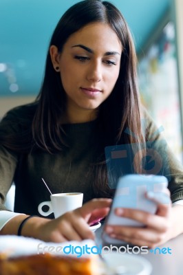 Beautiful Girl Using Her Mobile Phone In Cafe Stock Photo