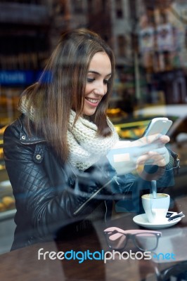 Beautiful Girl Using Her Mobile Phone In Cafe Stock Photo