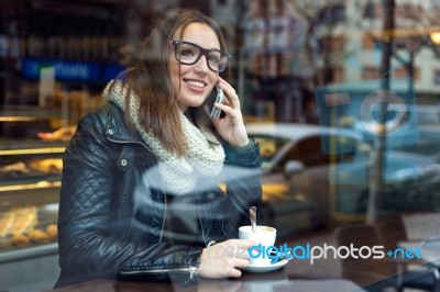 Beautiful Girl Using Her Mobile Phone In Cafe Stock Photo