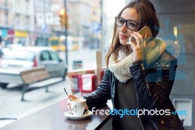 Beautiful Girl Using Her Mobile Phone In Cafe Stock Photo