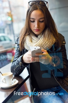 Beautiful Girl Using Her Mobile Phone In Cafe Stock Photo