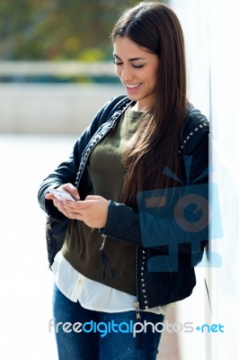 Beautiful Girl Using Her Mobile Phone In City Stock Photo