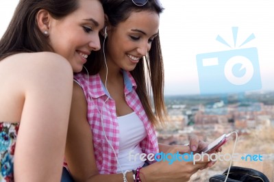 Beautiful Girls Sitting On The Roof And Listening To Music At Su… Stock Photo