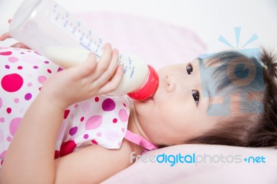 Beautiful Little Asian Girl Lying And Suck Up Milk Stock Photo