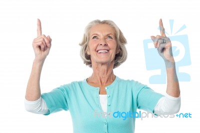 Beautiful Senior Lady Pointing Upwards Stock Photo