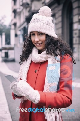 Beautiful Woman In Red Coat And Wool Cap And Gloves With Smartph… Stock Photo