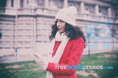 Beautiful Woman In Red Coat And Wool Cap And Gloves With Smartph… Stock Photo