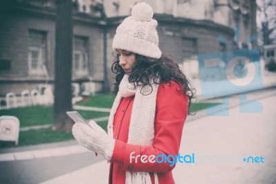 Beautiful Woman In Red Coat And Wool Cap And Gloves With Smartph… Stock Photo