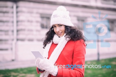 Beautiful Woman In Red Coat And Wool Cap And Gloves With Smartph… Stock Photo