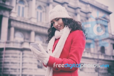 Beautiful Woman In Red Coat And Wool Cap And Gloves With Smartph… Stock Photo